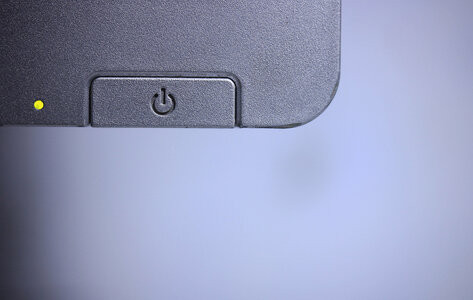 Ausschnitt von einem Monitor mit Taste zum An- und Ausschalten. Das Licht blinkt, das heißt, das Gerät ist an.