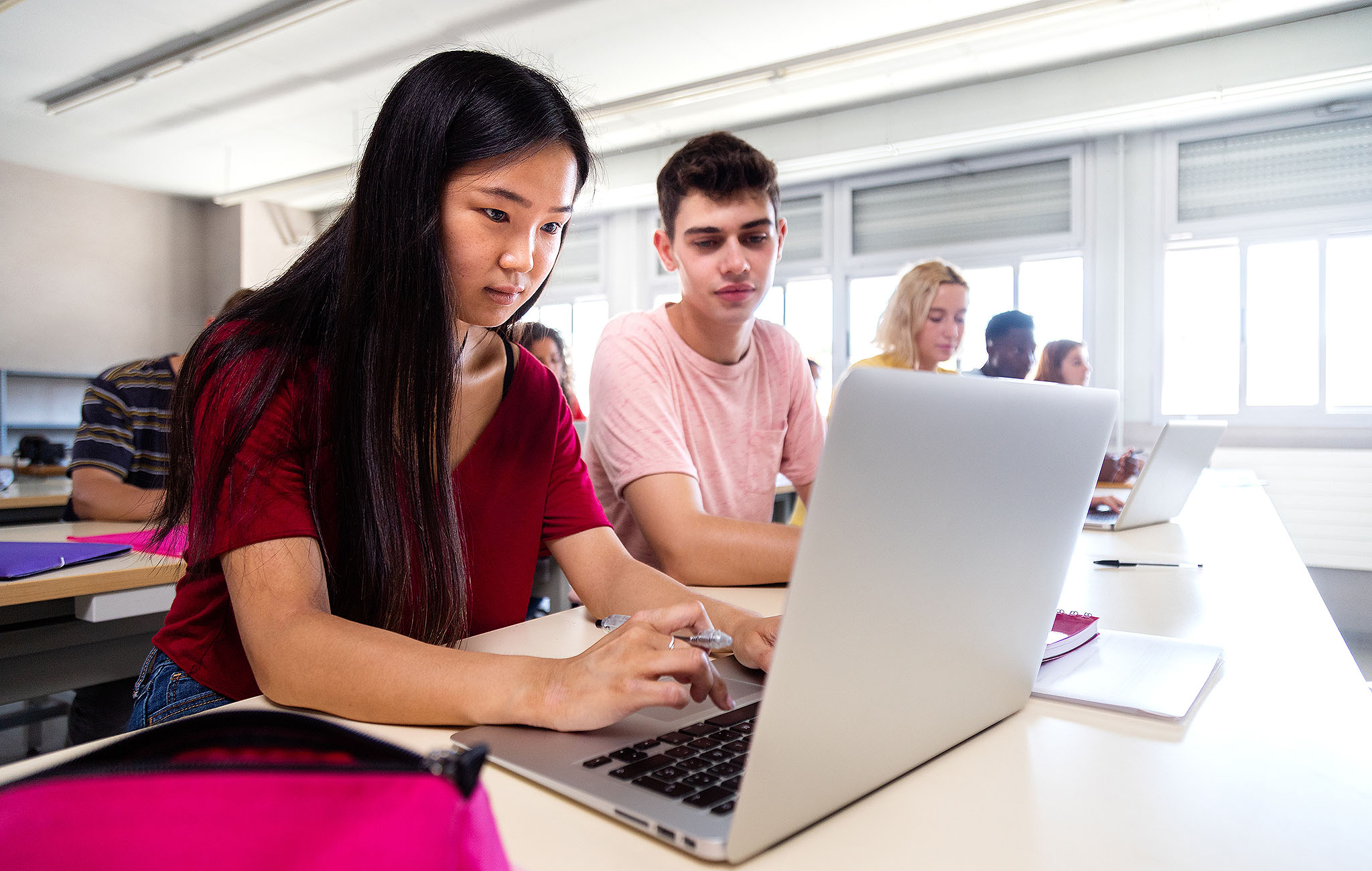 Schülerinnen und Schüler arbeiten gemeinsam an Laptops im Klassenzimmer – Symbolbild für moderne IT-Infrastruktur mit paedML Windows 5.3