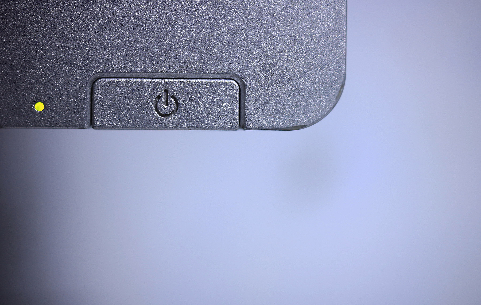 Ausschnitt von einem Monitor mit Taste zum An- und Ausschalten. Das Licht blinkt, das heißt, das Gerät ist an.